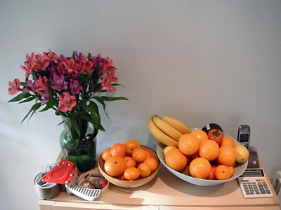 Vase, fruit bowl and other objects on a cupboad